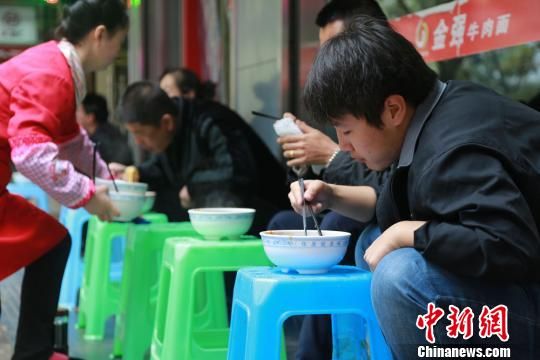 10月31日早,蘭州市永昌路一家牛肉面館門庭若市,20多平米的面館坐得滿滿當當,面館門外,顧客們有蹲著吃的,也有放個小板凳擱著吃的,取面口排成10余米的長隊。 劉玉桃 攝 10月31日早,蘭州市永昌路一家牛肉面館門庭若市,20多平米的面館坐得滿滿當當,面館門外,顧客們有蹲著吃的,也有放個小板凳擱著吃的,取面口排成10余米的長隊。 劉玉桃 攝